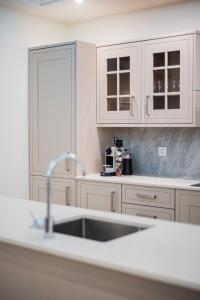 a kitchen with white cabinets and a sink at Apartamenty Rynek 7 by Hotel Żywiecki**** in Żywiec