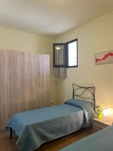 Un dormitorio con una cama azul y una ventana en Roy House, en Alghero