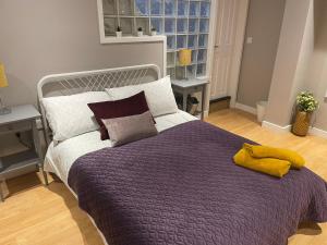 a bedroom with a bed with a purple blanket and pillows at Hot numbers in Cambridge