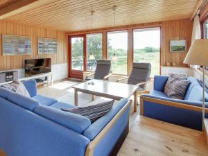een woonkamer met blauwe banken en een tafel bij Holiday Home Sweni - 800m from the sea in Western Jutland by Interhome in Fanø