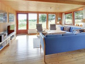 een woonkamer met een blauwe bank en een tv bij Holiday Home Sweni - 800m from the sea in Western Jutland by Interhome in Fanø