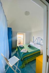 a bedroom with a bed and a chair in it at Domus Agricolae Corallina in Torre del Greco