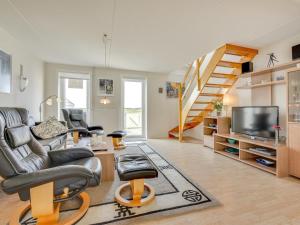 a living room with a couch and a tv and stairs at Apartment Helvig - 2-3km from the sea in Western Jutland by Interhome in Sønderby