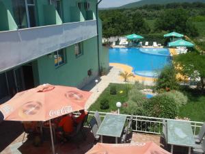 a patio with an umbrella and a swimming pool at Hotel Ankor in Kranevo