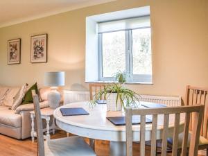 a living room with a table and a window at Meadow Cottage in Gowerton