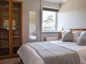 a bedroom with a large bed and a window at Meadow Cottage in Gowerton