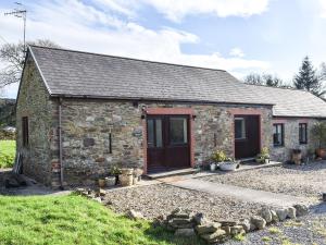 a stone cottage with a large door and a yard at Meadow Cottage in Gowerton