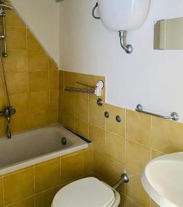 a bathroom with a toilet and a sink and a tub at Domus Agricolae Corallina in Torre del Greco