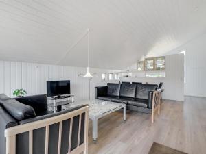 een woonkamer met een bank en een tafel bij Holiday Home Thera - 2-8km from the sea in Western Jutland by Interhome in Bolilmark