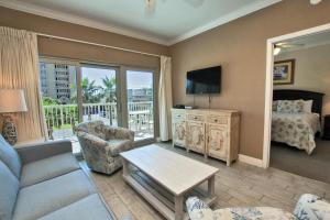 sala de estar con sofá, TV y cama en Crystal Tower 208 en Gulf Shores