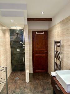 a bathroom with a shower and a wooden door at Lisa's home Piedimonte Etneo in Piedimonte Etneo