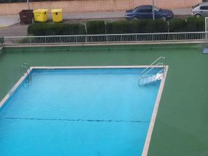 una gran piscina azul con un cartel en el agua en Apartamento playa, en La Pobla de Farnals