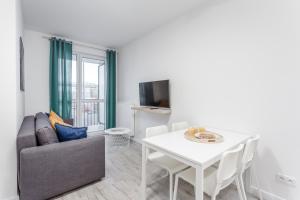 een woonkamer met een witte tafel en een bank bij Chill Apartments Ursynów in Warschau