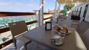 a table with a cup of coffee and bread on a balcony at Villa con Piscina Privata fronte Spiaggia in Santa Marinella