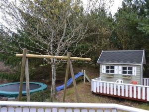 een speeltuin met een glijbaan en een klein huisje bij Holiday Home Karlotta - 2-2km from the sea in Western Jutland by Interhome in Bolilmark