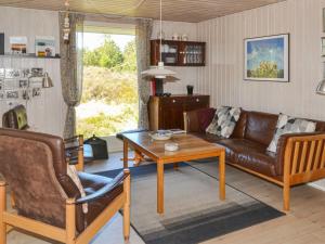 een woonkamer met een bank en een tafel bij Holiday Home Karlotta - 2-2km from the sea in Western Jutland by Interhome in Bolilmark