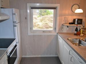 een kleine keuken met een raam en een wastafel bij Holiday Home Karlotta - 2-2km from the sea in Western Jutland by Interhome in Bolilmark