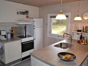 a kitchen with white appliances and a bowl of fruit on a counter at Holiday Home Karlotta - 2-2km from the sea in Western Jutland by Interhome in Bolilmark