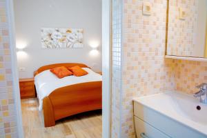 a small bedroom with a bed and a sink at Apartments Mala Vila in Rab