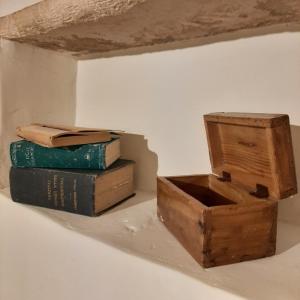 due libri e una scatola di legno su un muro di Lumè a Putignano