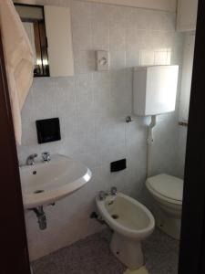 a bathroom with a sink and a toilet at Mon Hotel in Misano Adriatico