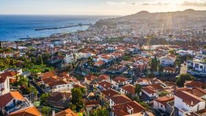 an aerial view of a city with houses and the ocean at Casa da Pinheira 2 in Funchal
