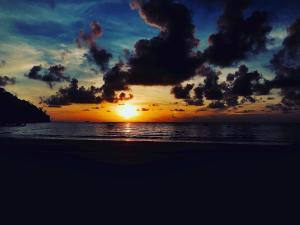 a sunset on a beach with the ocean at Tiongman Scubadive & Lodge in Tioman Island