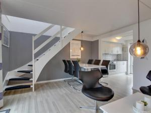 een keuken en eetkamer met een trap en een tafel en stoelen bij Apartment Raine - 2-3km from the sea in Western Jutland by Interhome in Sønderby