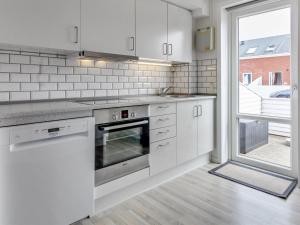 een keuken met witte apparatuur en een groot raam bij Apartment Raine - 2-3km from the sea in Western Jutland by Interhome in Sønderby