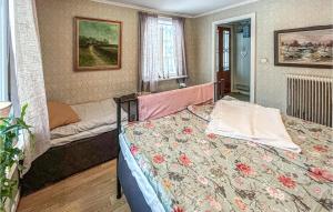 1 dormitorio con 1 cama con colcha de flores en Amazing Home In Tingsryd With House A Panoramic View en Tingsryd