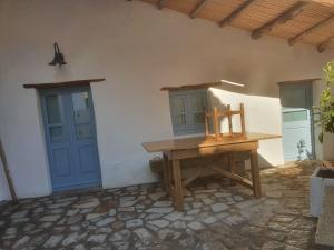 Habitación con mesa de madera y puerta azul. en Casetta da scoprire a due passi dal centro en Tortolì