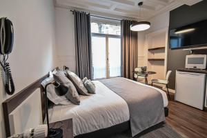 a hotel room with a bed and a tv and a kitchen at Les cles du 27 Paris in Paris