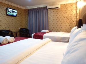 Säng eller sängar i ett rum på Classic Kinabalu Hotel