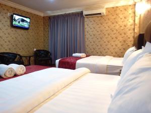 Postel nebo postele na pokoji v ubytování Classic Kinabalu Hotel