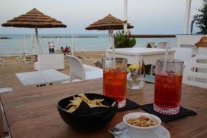 a table with two drinks and a bowl of food on the beach at Prati di Maja B&B in Miglianico