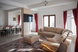 sala de estar con sofá, TV y mesa en Pensiunea Andaluz, en Poiana Micului