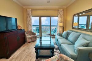 a living room with a couch and a flat screen tv at Crystal Tower 1705 in Gulf Shores
