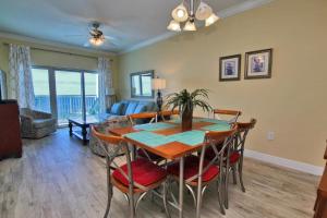 a dining room and living room with a table and chairs at Crystal Tower 1705 in Gulf Shores