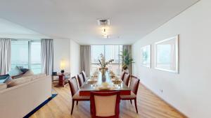 - une salle à manger avec une table, des chaises et un canapé dans l'établissement Blue Beach Tower The Walk JBR, à Dubaï