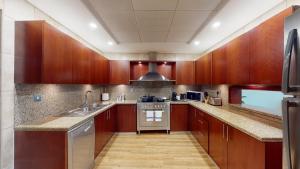 a kitchen with wooden cabinets and stainless steel appliances at Blue Beach Tower The Walk JBR in Dubai