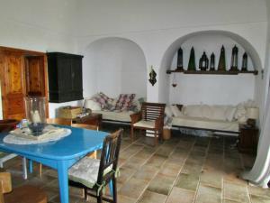 a living room with a blue table and a couch at Antico Dammuso Al Tramonto in Pantelleria