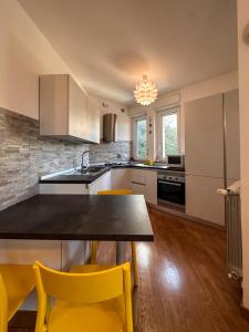 a kitchen with a table and yellow chairs in it at La casa di Soddy in Albano Laziale