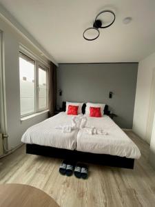 a bedroom with a large bed with two red pillows at The Diem Amsterdam in Amsterdam