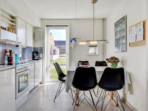 a kitchen with a table and black chairs in it at Apartment Odger - 2-3km from the sea in Western Jutland by Interhome in Sønderby