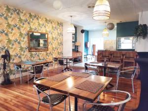 a restaurant with tables and chairs in a room with a wall at Thistle Hotel in Pietermaritzburg