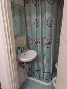 łazienka z umywalką i zasłoną prysznicową w obiekcie Monolocale Micarè 19 w mieście Roccella Ionica