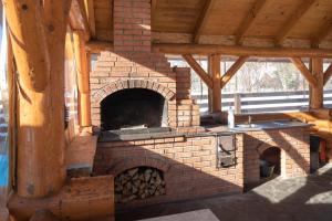 an outdoor brick oven with a wooden roof at Pensiunea Andaluz in Poiana Micului