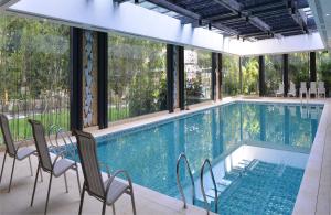 a large swimming pool with chairs and windows at Guangdong Yingbin Hotel in Guangzhou