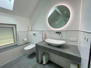 a white bathroom with a sink and a mirror at Sauwohlfühlhof - Ferienhof Winkelkötter in Everswinkel
