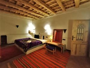 a bedroom with a bed and a desk and a door at Riad Bleu Afriqua in Boumalne